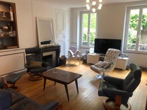 a living room with a couch and chairs and a table at Villa Eugénie Melun in Melun