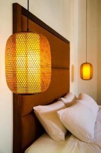 a bedroom with a bed with two pillows and a lamp at Ren I Tang Heritage Inn in George Town