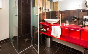 y baño con lavabo rojo y ducha. en Hotel Aiterbach am Chiemsee, en Rimsting
