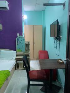 Pokój ze stołem, łóżkiem i telewizorem w obiekcie Happy Hotel Binh Tan w Ho Chi Minh