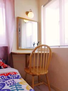 specchio e sedia in legno in una stanza di Aurora Court Service Apartment a Kampong Makam