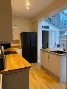 a kitchen with a black refrigerator and wooden floors at Albion House in Doncaster