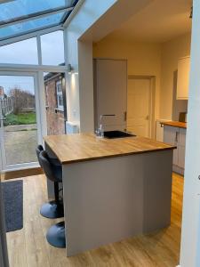 a kitchen with a counter with a sink and two chairs at Albion House in Doncaster