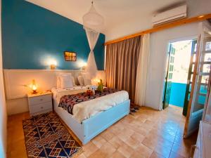 um quarto com uma cama com uma parede azul em El Gezira Hotel em Luxor