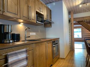 a kitchen with wooden cabinets and a sink at Krüüdneri puhkemaja in Krüüdneri