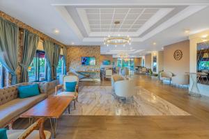 a hotel lobby with couches and tables and chairs at Justiniano Club Park Conti in Okurcalar