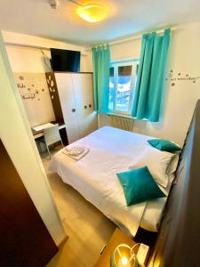 a bedroom with a large bed with blue curtains at Hotel B&B Lorenzini Ski in Selva di Cadore