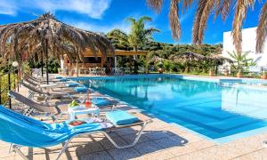 a swimming pool with lounge chairs and a resort at Welcome Apts in Georgioupolis