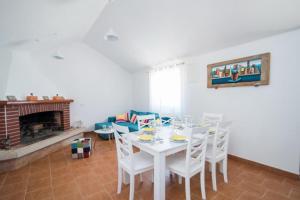 a white dining room with a white table and chairs at Holiday Home My Summer House in Supetar