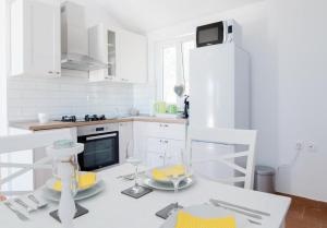 uma cozinha branca com uma mesa com copos de vinho em Holiday Home My Summer House em Supetar