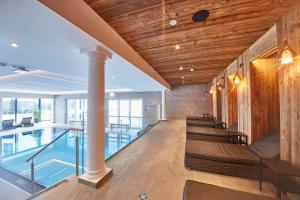 an indoor pool with benches and a table in a building at Hotel Römerhof in Fusch an der Glocknerstraße
