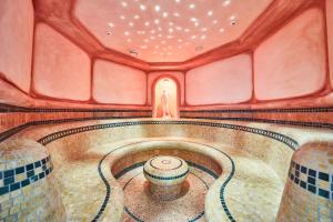 a swimming pool in a room with a tile floor at Hotel Römerhof in Fusch an der Glocknerstraße