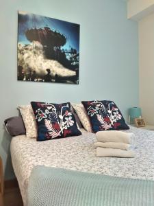 ein Bett mit Kissen und ein Bild an der Wand in der Unterkunft Nant'Sud Loire in Nantes