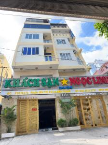 un grand bâtiment blanc avec un panneau au-dessus d'un magasin dans l'établissement Ngoc Linh Hotel, à Hô-Chi-Minh-Ville