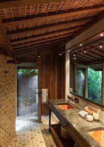 La salle de bains est pourvue de 2 lavabos et d'un grand miroir. dans l'établissement The Asa Maia - Adults Only Resort, à Uluwatu