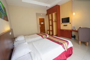 Tempat tidur dalam kamar di Bangka City Hotel