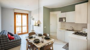 een keuken en een woonkamer met een tafel en stoelen bij Maison Olga - Incantevole Nuovo Trilocale Vista Mare con parcheggio in Borghetto Santo Spirito