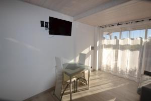 een kleine woonkamer met een tafel en een televisie bij Studio Naturiste "ALCOVE" Port Nature 706 in Cap d'Agde