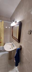 a bathroom with a sink and a mirror and a tub at Casa Rural de Tio Tango II in Cardeñosa