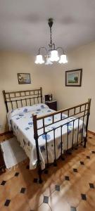 a bedroom with a bed and a chandelier at Casa Rural de Tio Tango II in Cardeñosa