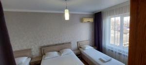 two beds in a room with a window at Apartaments Vityzevo in Vityazevo