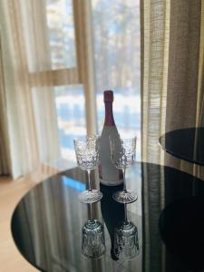 eine Flasche Wein und zwei Gläser auf dem Tisch in der Unterkunft Greenwood apartments in Druskininkai