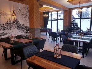 a restaurant with tables and chairs and a christmas tree at Apartamenty Pod Tatrzańskim Niebem in Zakopane