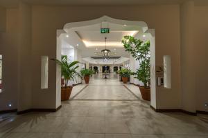 an empty hallway with potted plants in a building at PrideInn Paradise Beach Resort & Spa Mombasa in Mombasa +101 photos