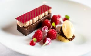 a piece of chocolate dessert with berries on a white plate at Saxon Hotel, Villas & Spa in Johannesburg