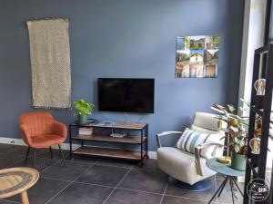 a living room with a tv and a couch and chairs at Nieuw Molenwijk 4-5 persoons in Oostkapelle