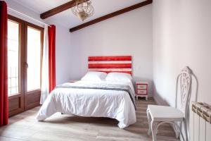 a bedroom with a bed with a red and white headboard at APARTAMENTOS LA VIEJA IMPRENTA in Sigüenza