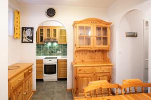 una cucina con armadi in legno, tavolo e sedie di Apartments Baki Kranjska Gora a Kranjska Gora