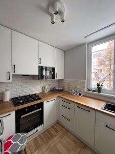 a kitchen with white cabinets and a stove top oven at Apartament Wspomnienie in Duszniki Zdrój