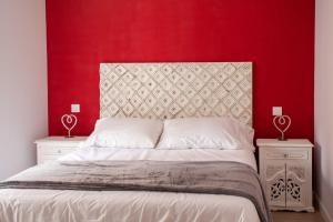 um quarto com uma cama com uma parede vermelha em APARTAMENTOS LA VIEJA IMPRENTA em Sigüenza