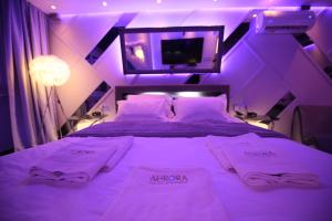 a purple room with a bed with towels on it at Aurora Lux Spa Smart apartments in Belgrade
