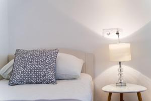 a bedroom with a bed with a lamp and a pillow at Holiday Home Kazerma in Dubrovnik