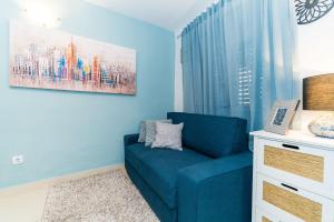 a blue living room with a blue couch and a window at Holiday Home Kazerma in Dubrovnik
