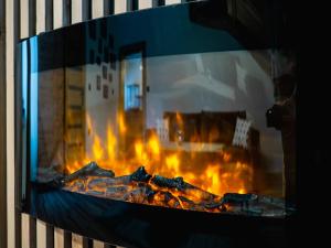 a fire in a fireplace with flames in it at Domek RiverHut Małe Ciche - SkyWalk - blisko do szlaków TPN in Małe Ciche