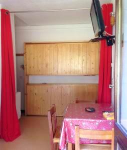 - une salle à manger avec une table et une télévision dans la chambre dans l'établissement Studio cosy avec vue sur la montagne - Les Belleville - 20 m², aux Menuires