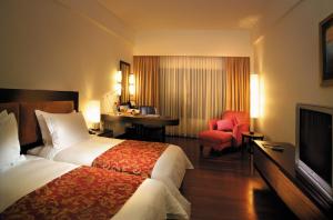 Habitación de hotel con cama, escritorio y TV. en Impiana KLCC Hotel en Kuala Lumpur