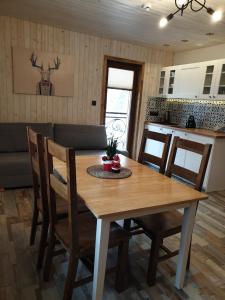 Il comprend une cuisine et une salle à manger avec une table et des chaises en bois. dans l'établissement Izba w centrum miasta, à Zakopane