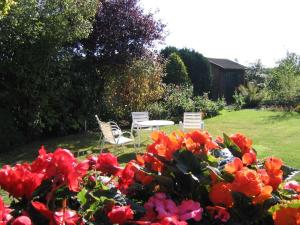 a table and chairs in a garden with flowers at Volker Callsen Ferienwohnungen in Gelting +6 photos