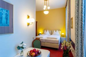 a hotel room with a bed and a table with a bowl of fruit at Theaterhotel & Suites Wien in Vienna +36 photos