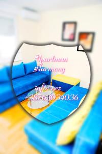 a reflection of a blue couch in a mirror at Apartman Harmony in Lukavica