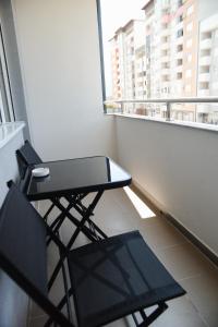 a balcony with a table and a chair on a balcony at Apartman Harmony in Lukavica +2 photos