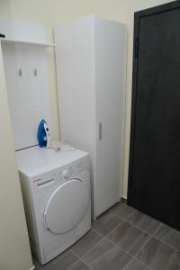 a white washer and dryer in a room at Apartman Harmony in Lukavica