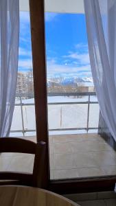 a room with a window with a view of the snow at Superbe appartement à 50m des pistes parking privé in La Toussuire