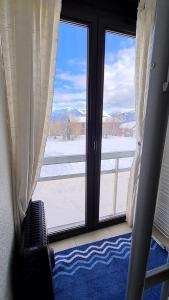 a room with a window with a view of snow at Superbe appartement à 50m des pistes parking privé in La Toussuire