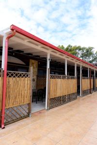 awning on a porch of a building with a patio at Giardini Sausari Residence in Punta Prosciutto