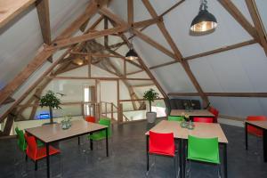 an attic dining room with two tables and colorful chairs at Bed & Breakfast Notterveld in Notter